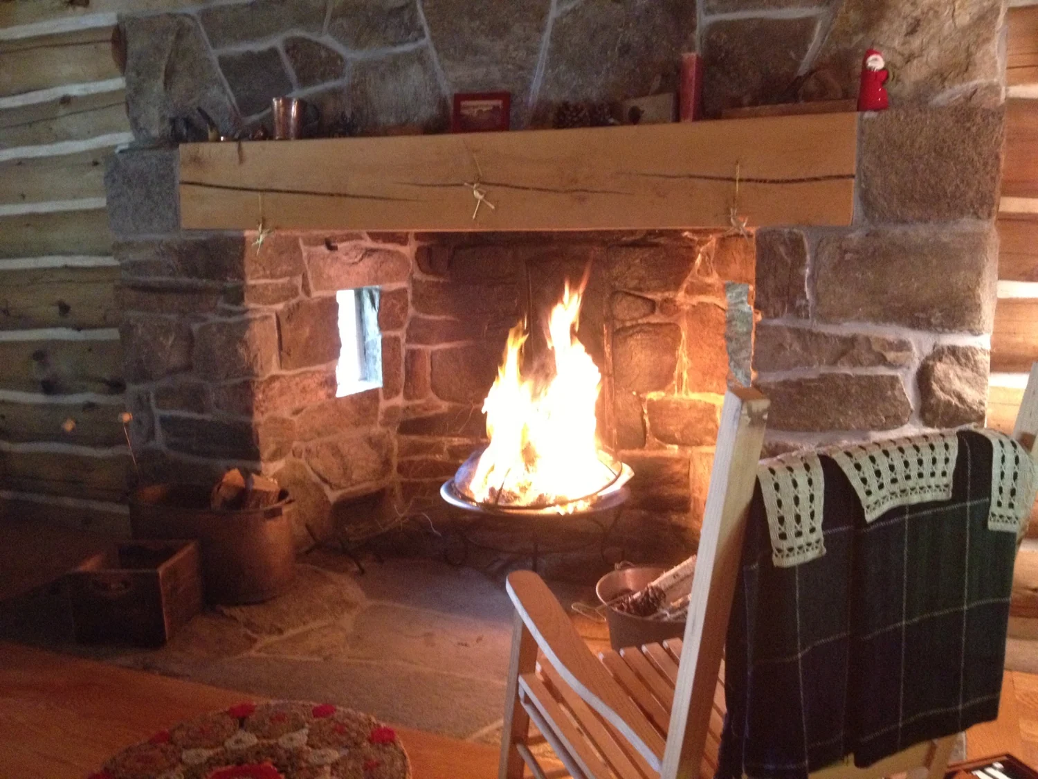 A fire burning in a stone fireplace inside the cabin.